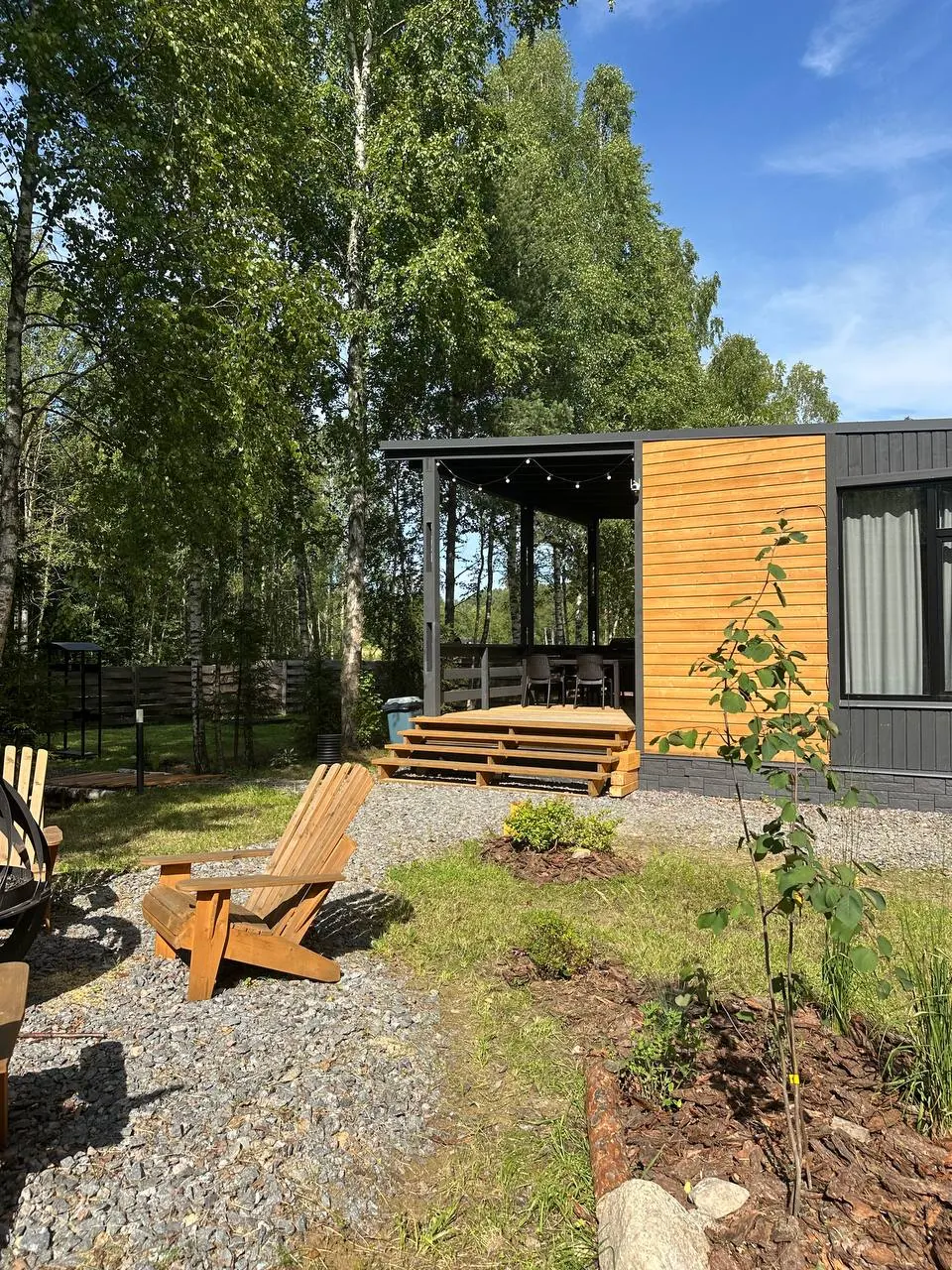 Дом Mint House и деревянные кресла на поляне